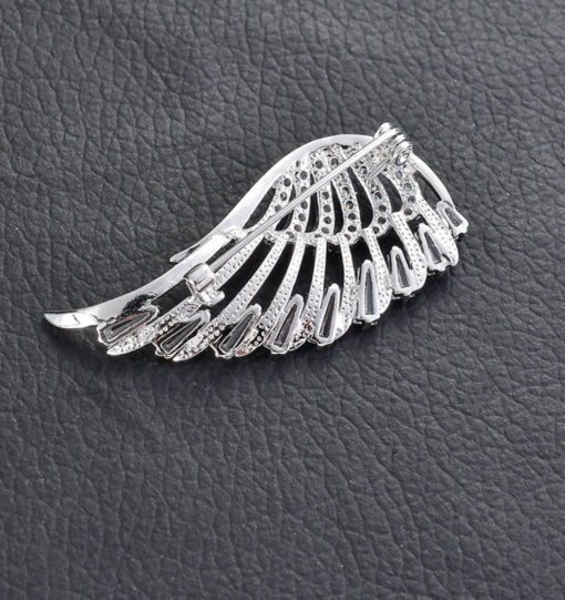 Štýlová brošňa v podobe strieborného krídla s kryštálikmi